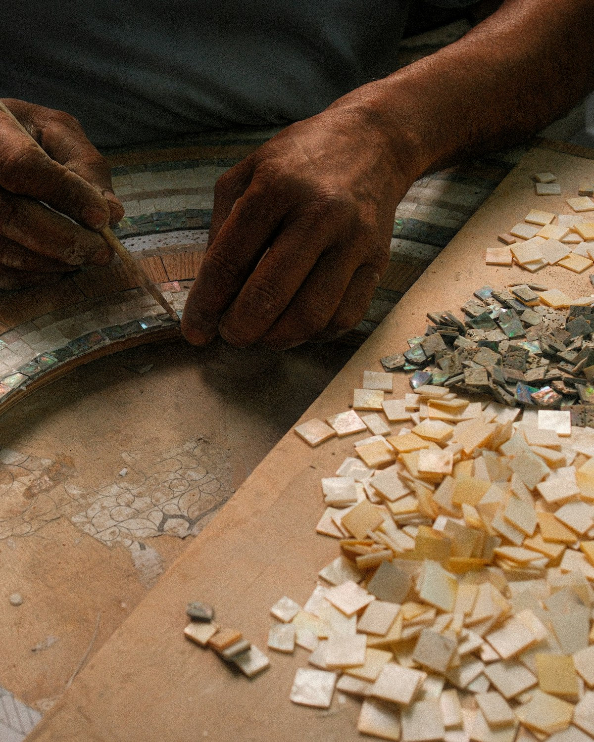 Deelnemers maken kleurrijke ontwerpen tijdens een Mozaïek Workshop.