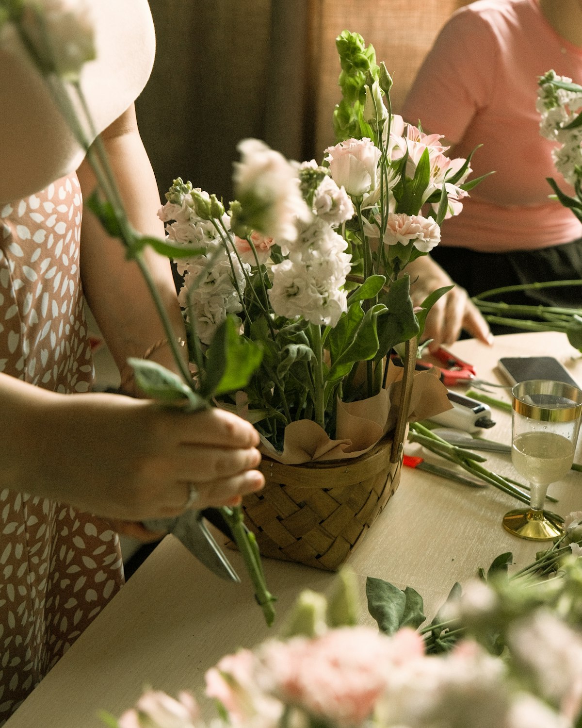Deelnemers maken bloemencreaties tijdens een workshop op locatie.