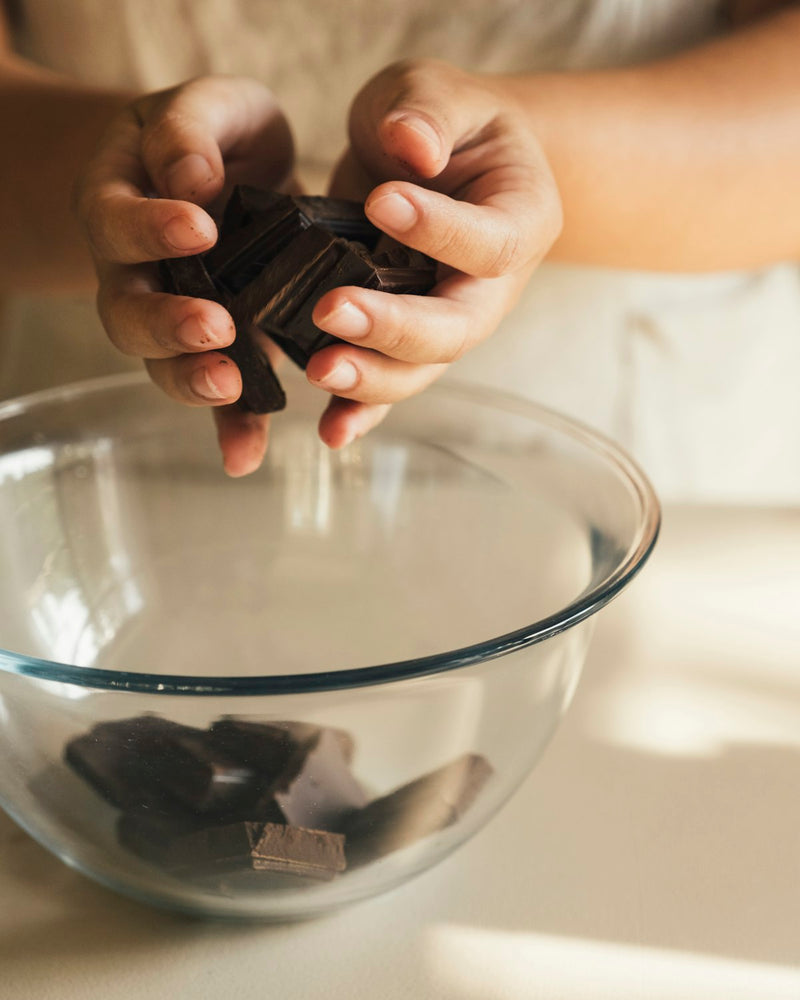 Deelnemers decoreren chocolade tijdens een workshop op locatie.