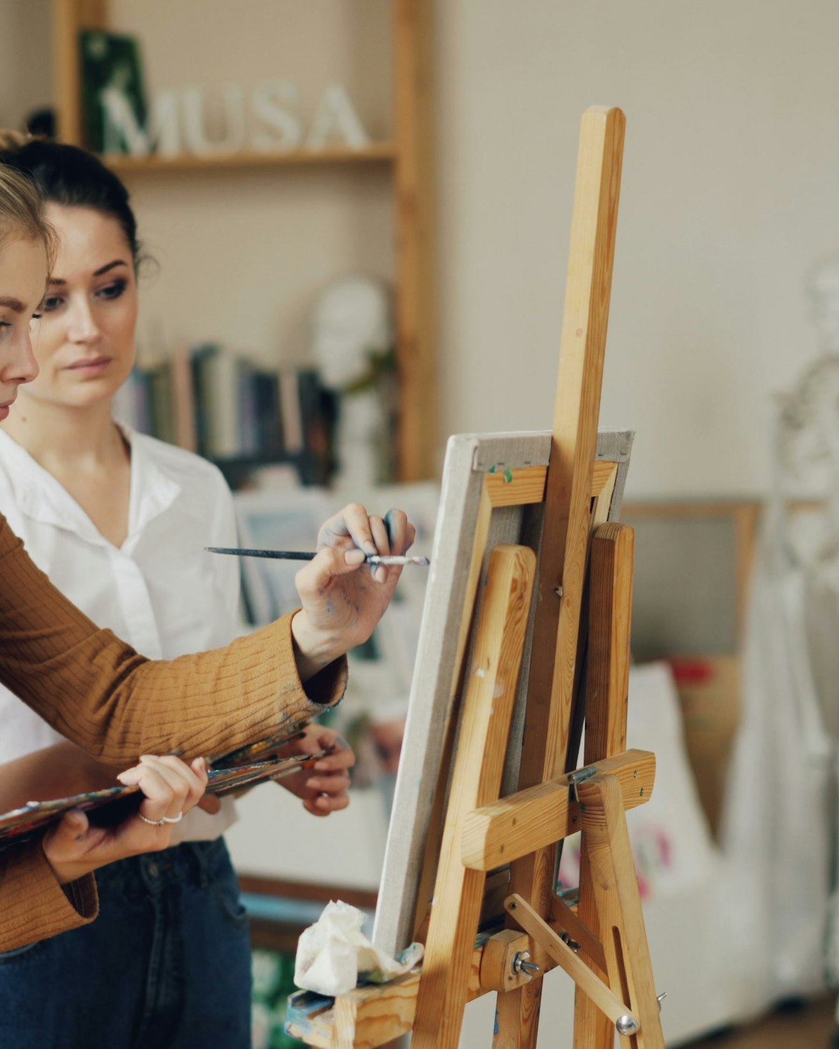 Deelnemers maken schilderijen tijdens een creatieve workshop.